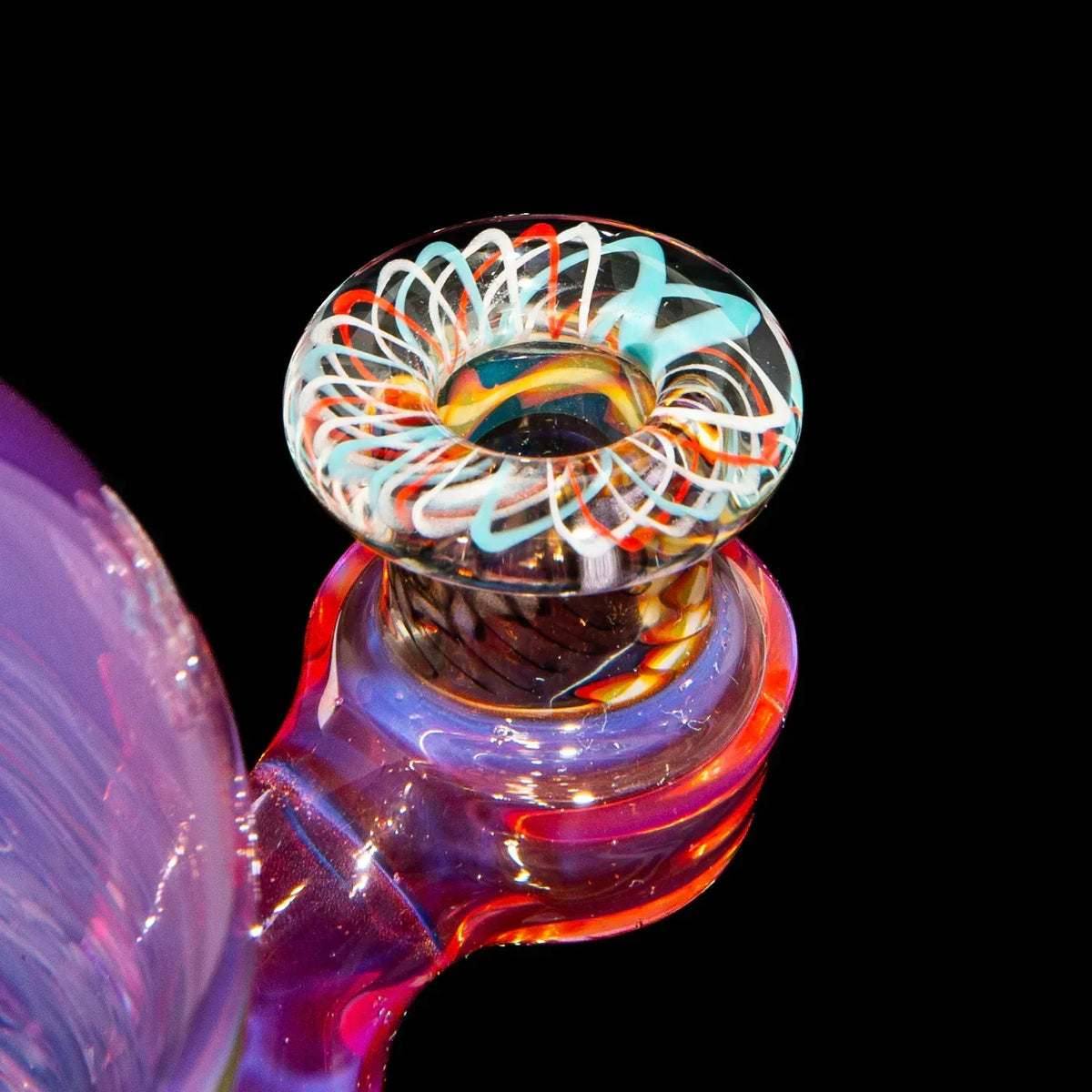 Close-up of colorful heady glass pipe with intricate swirl design and vibrant colors on black background