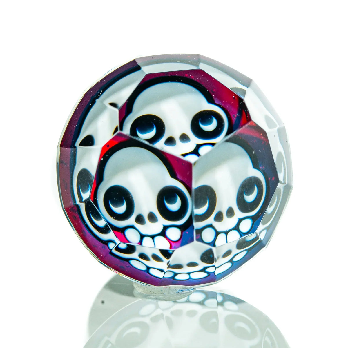 Faceted glass cap with multiple skull designs, reflective surface, heady glass accessory