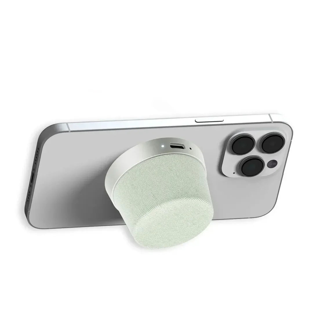 Magnetic mini Bluetooth speaker attached to back of a modern smartphone