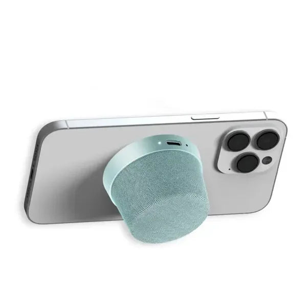 Compact teal wireless speaker attached to the back of a smartphone