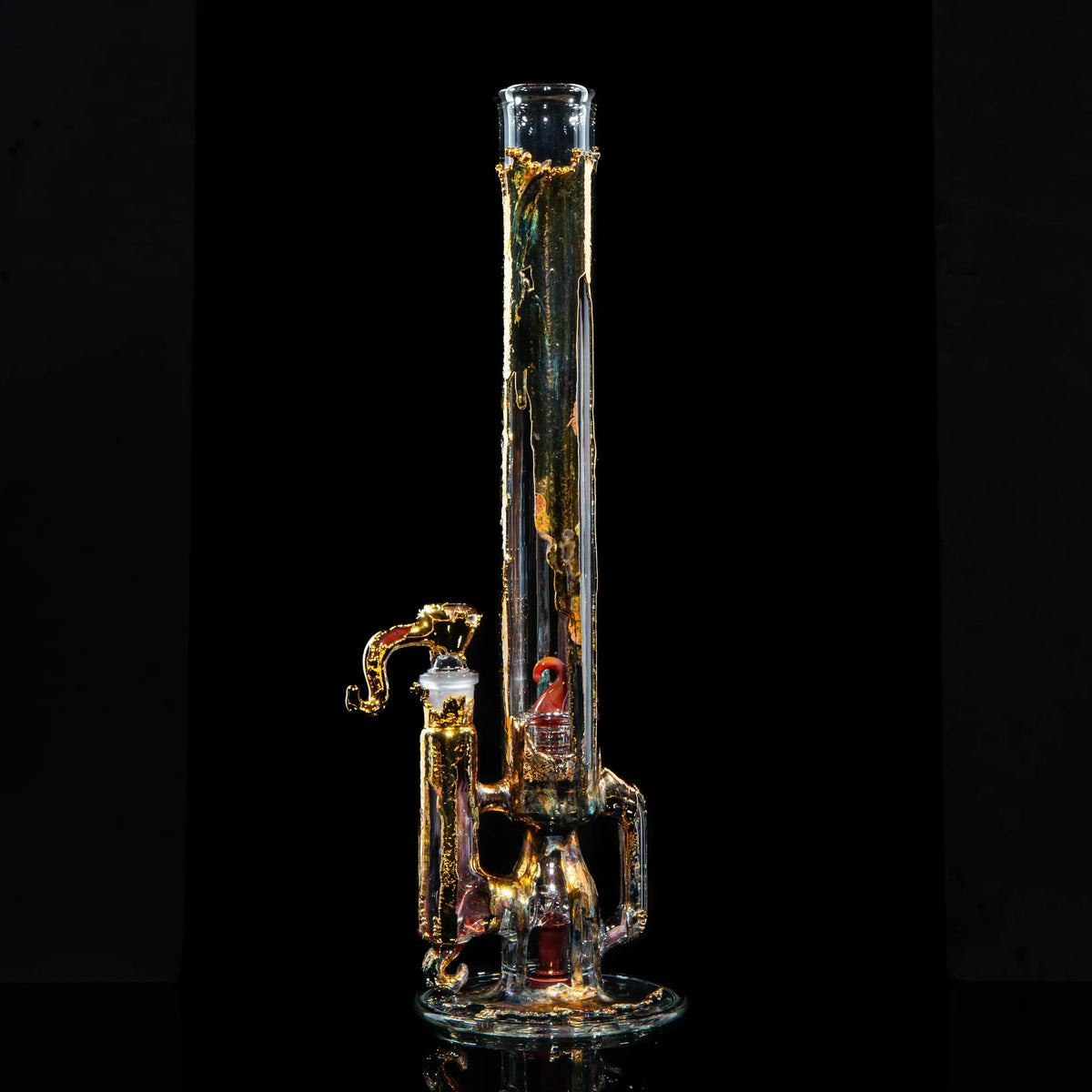 Heady glass water pipe with intricate gold and clear glass details on black background