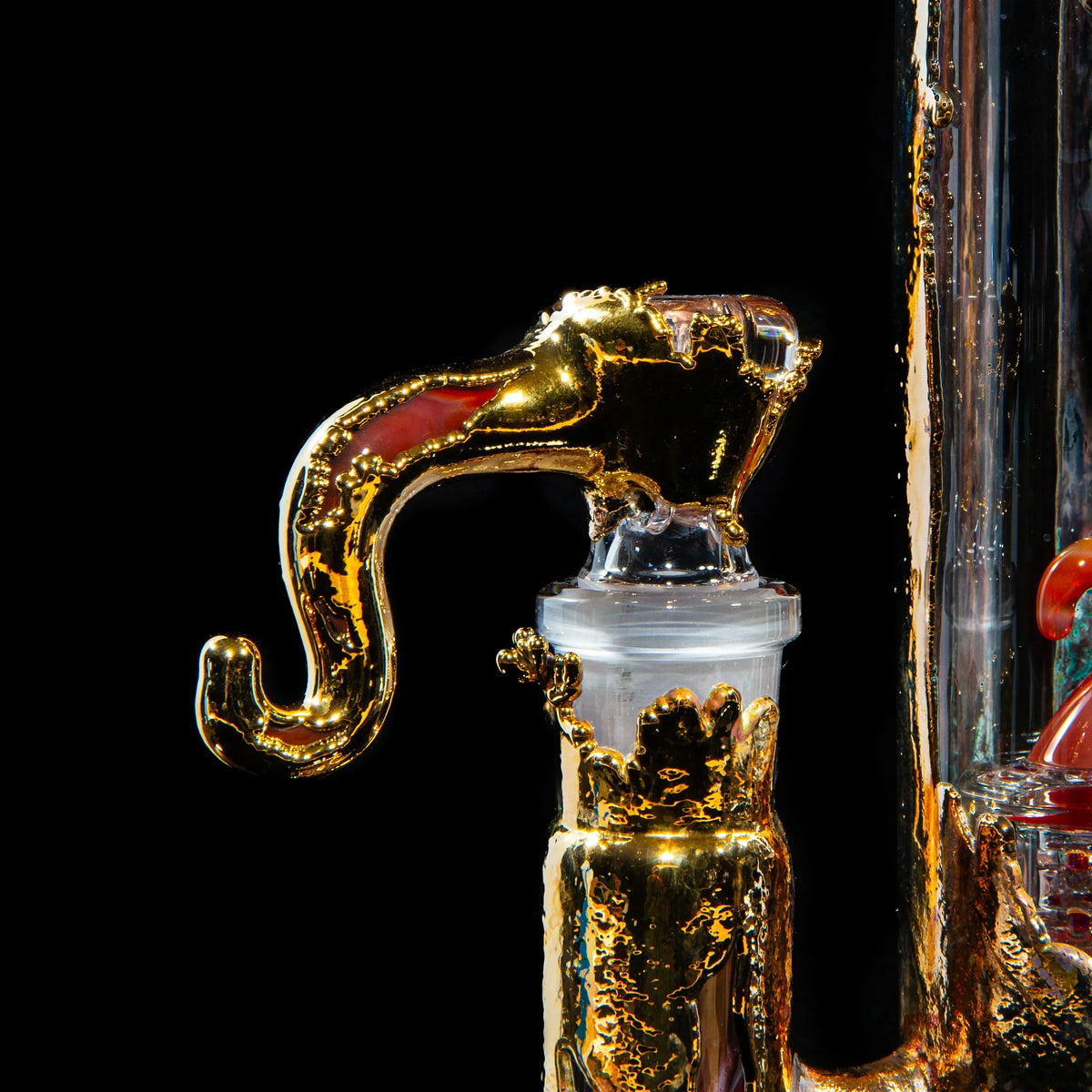 Close-up of a gold-accented glass pipe attachment with intricate detailing