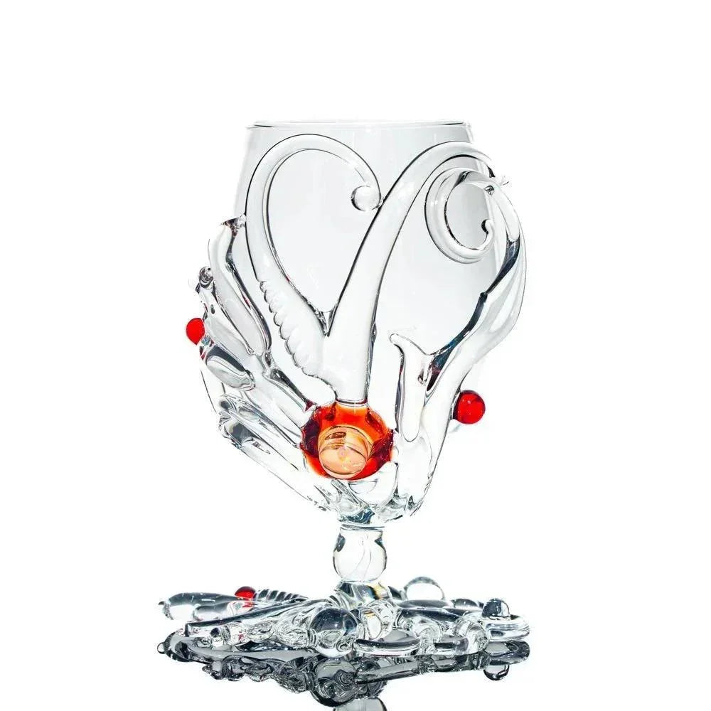 Artistic clear glass water pipe with intricate swirls and red accent details on a white background.