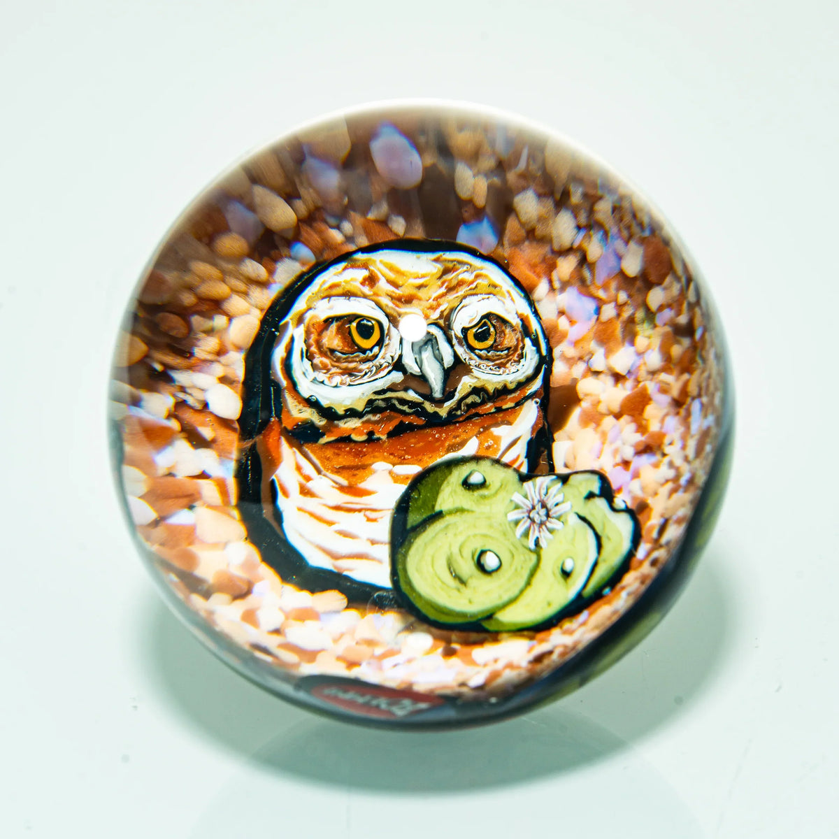 Handmade glass art marble featuring a detailed owl and green cactus design