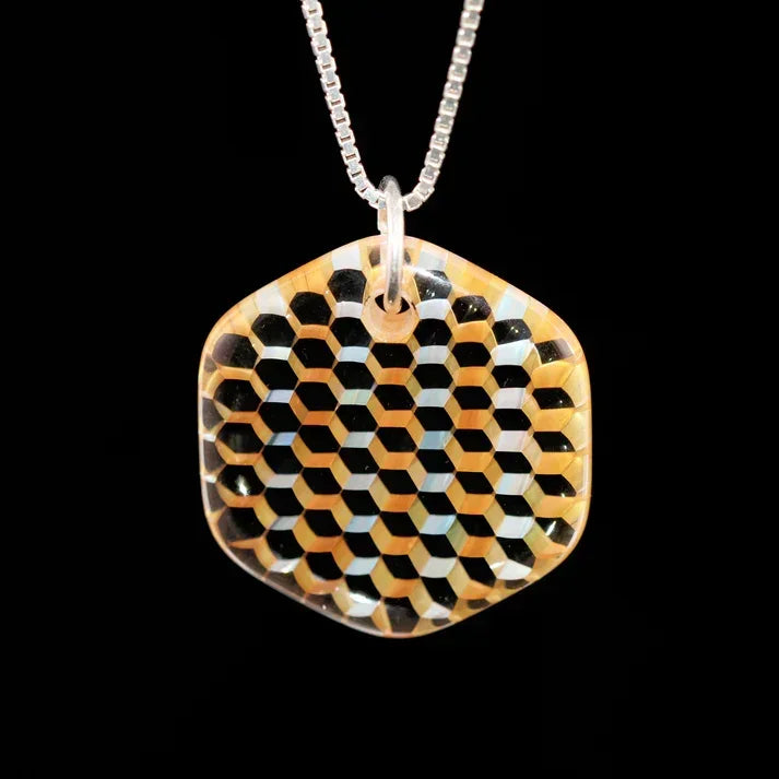 Glass pendant with geometric honeycomb pattern on a chain, black and amber colors
