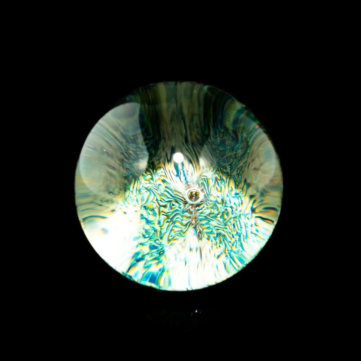 Close-up of a colorful, intricate glass marble with swirling patterns on a black background.