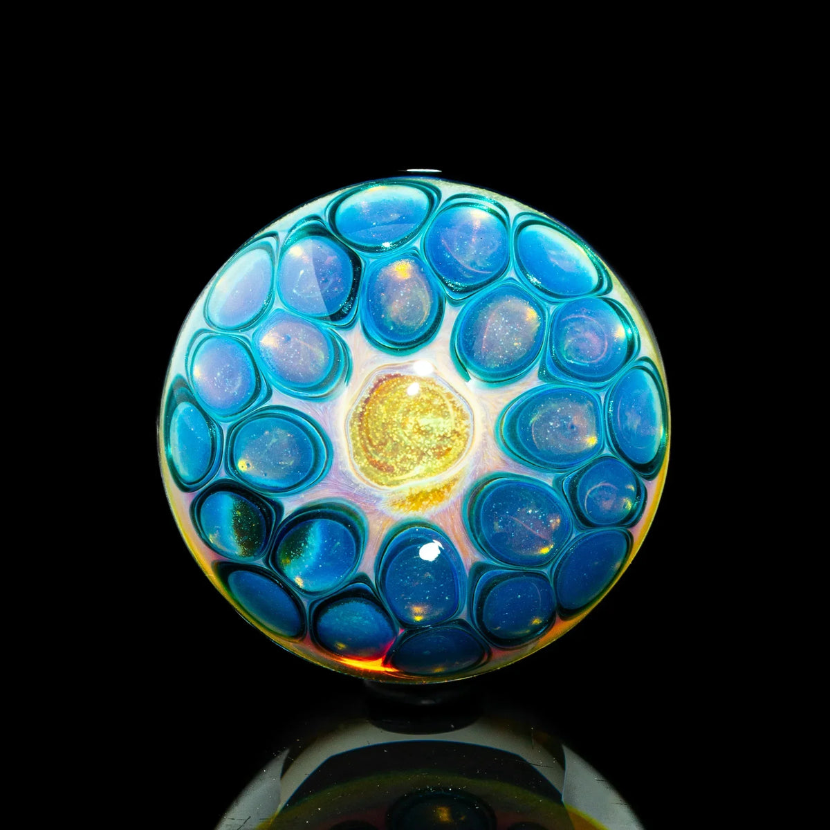 Heady glass marble with blue and gold opal-like design on black background
