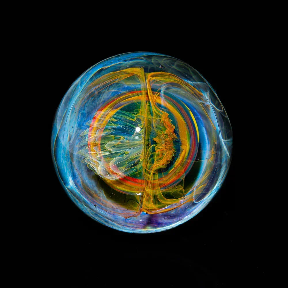 Colorful heady glass marble with swirling patterns on a black background