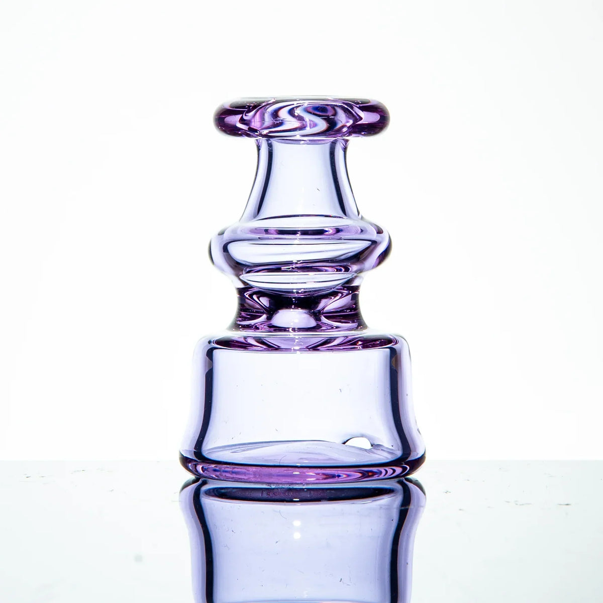 Purple glass bubble cap with reflective base on white background, heady glass accessory