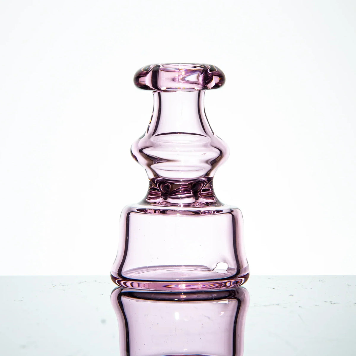 Purple glass carb cap with a unique sculpted shape for vaporizers on white background