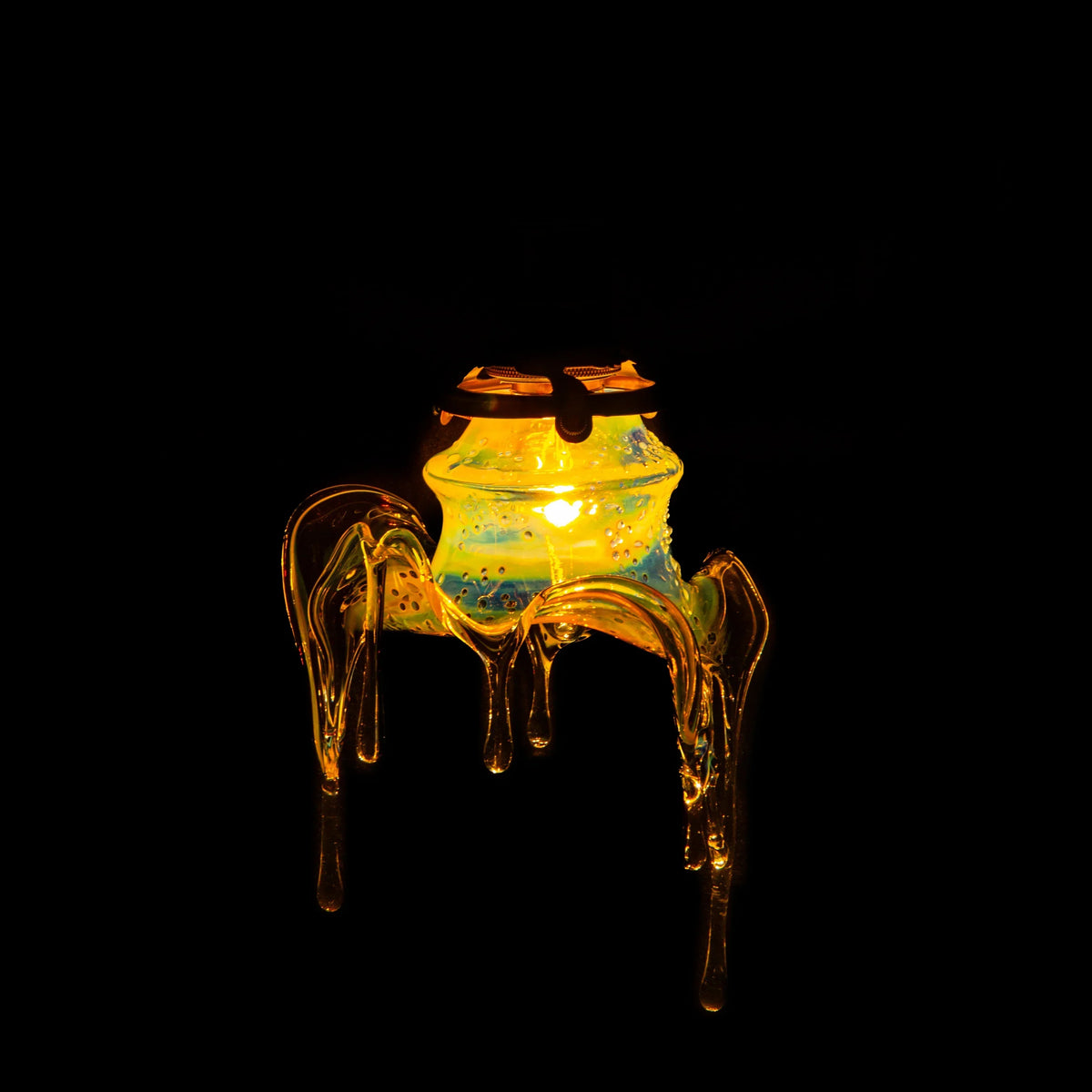 Artistic glass lamp with glowing yellow light and unique dripping glass design