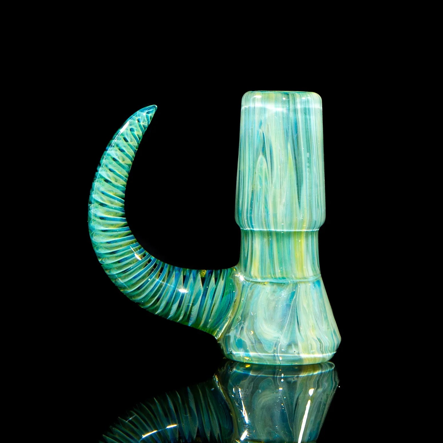 Handcrafted blue and green glass slide with spiral horn, displayed on a reflective black surface.