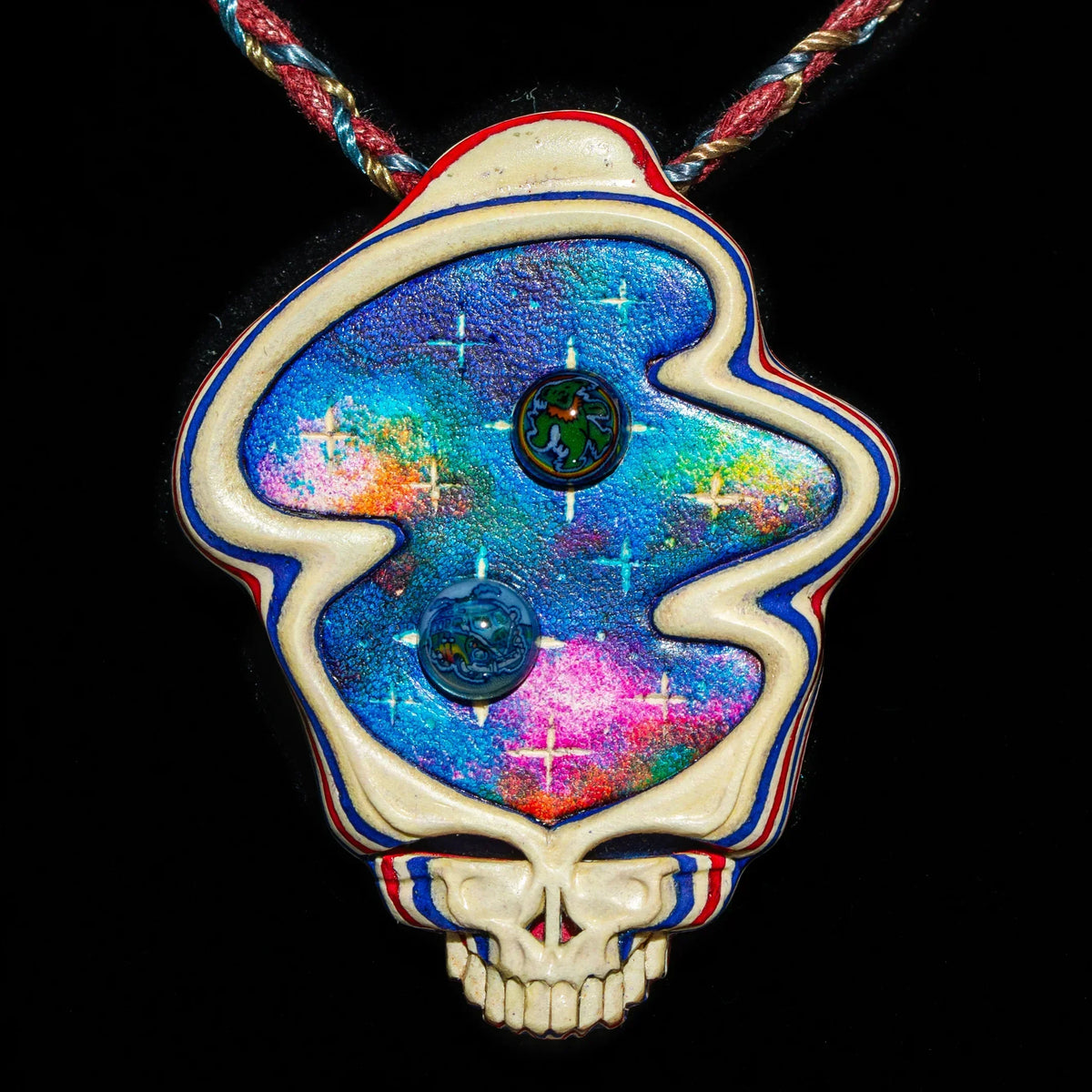 Colorful skull-shaped glass pendant with cosmic design on braided cord
