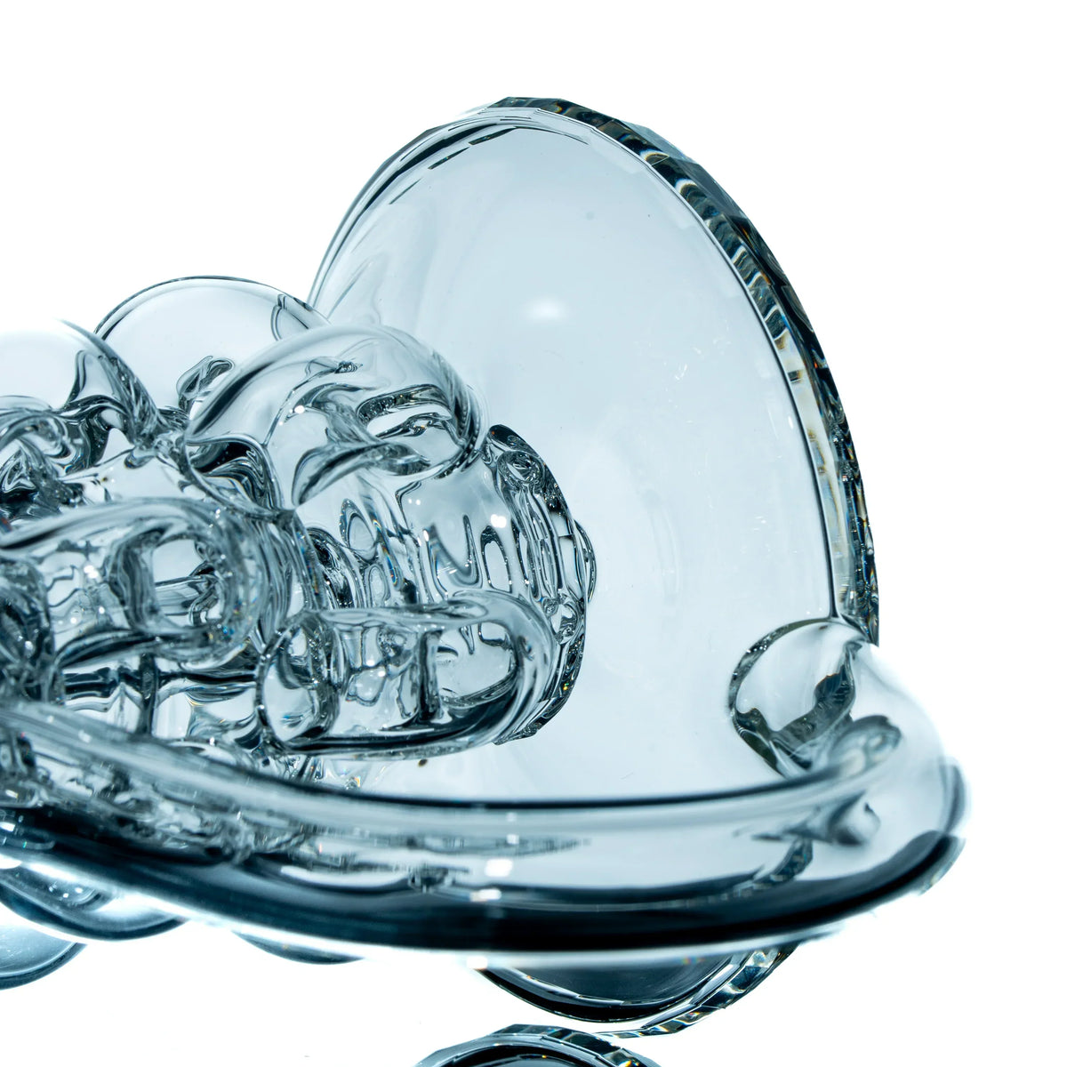 Intricately blown clear glass art piece with abstract patterns on a white background