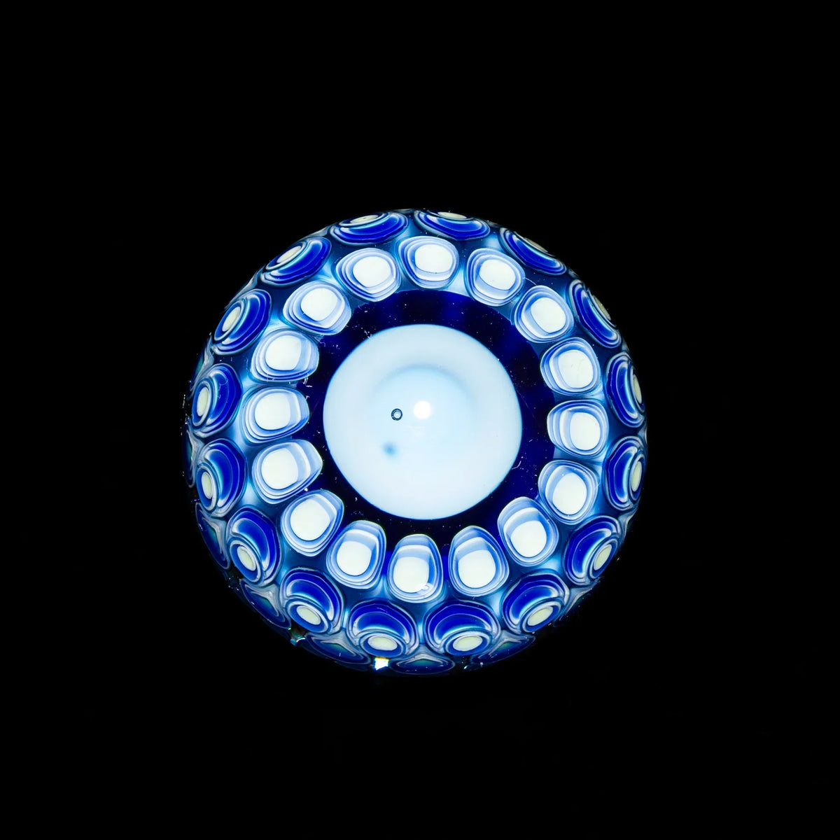 Blue and white patterned glass marble with intricate design, shown on a black background.