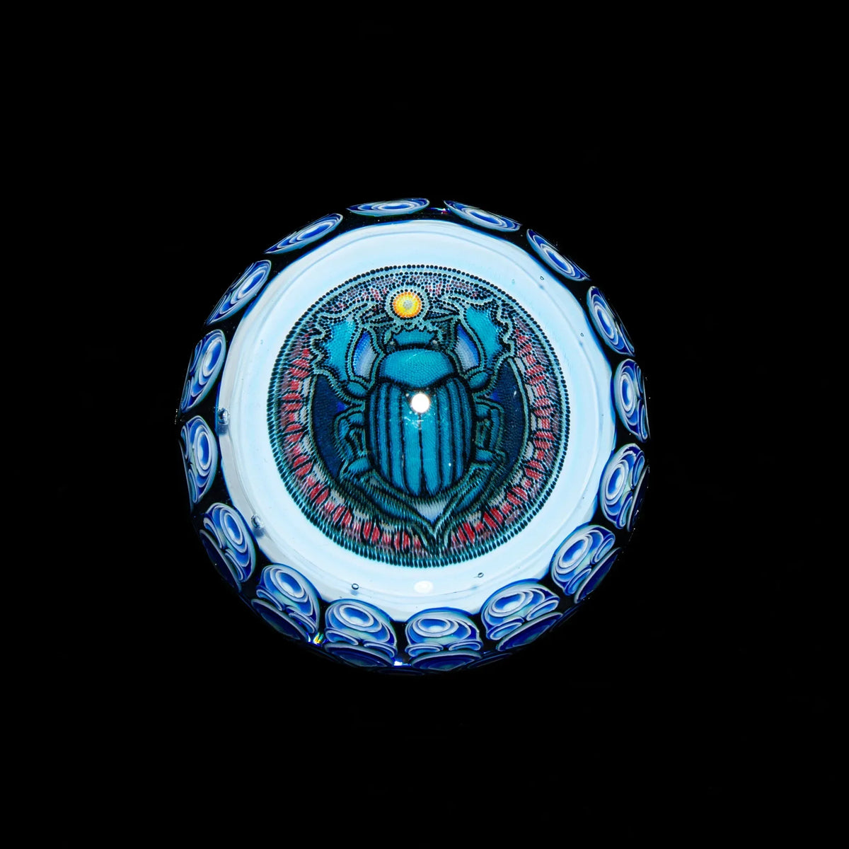 Blue glass art marble with detailed scarab beetle design and intricate patterns