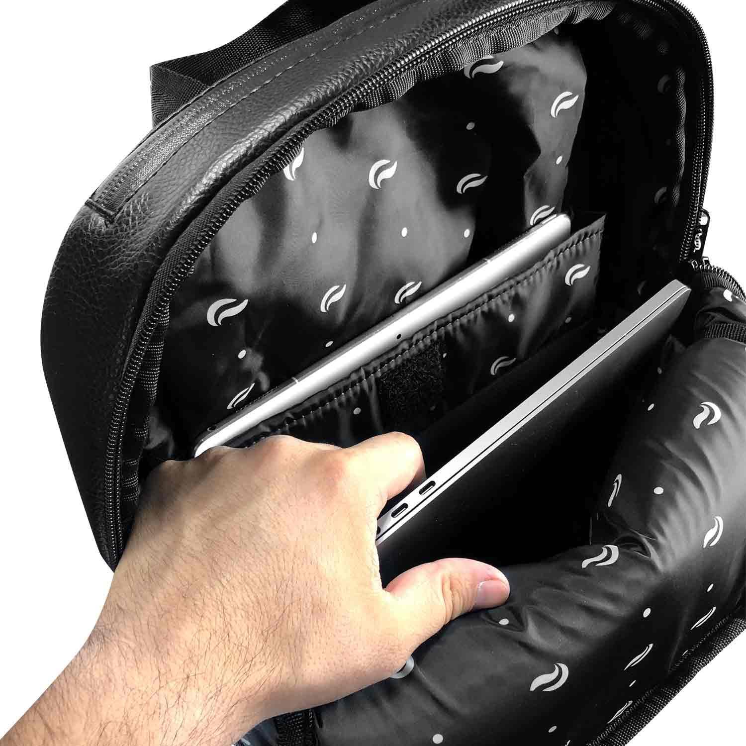 Hand placing a laptop into padded, black backpack with protective laptop sleeve