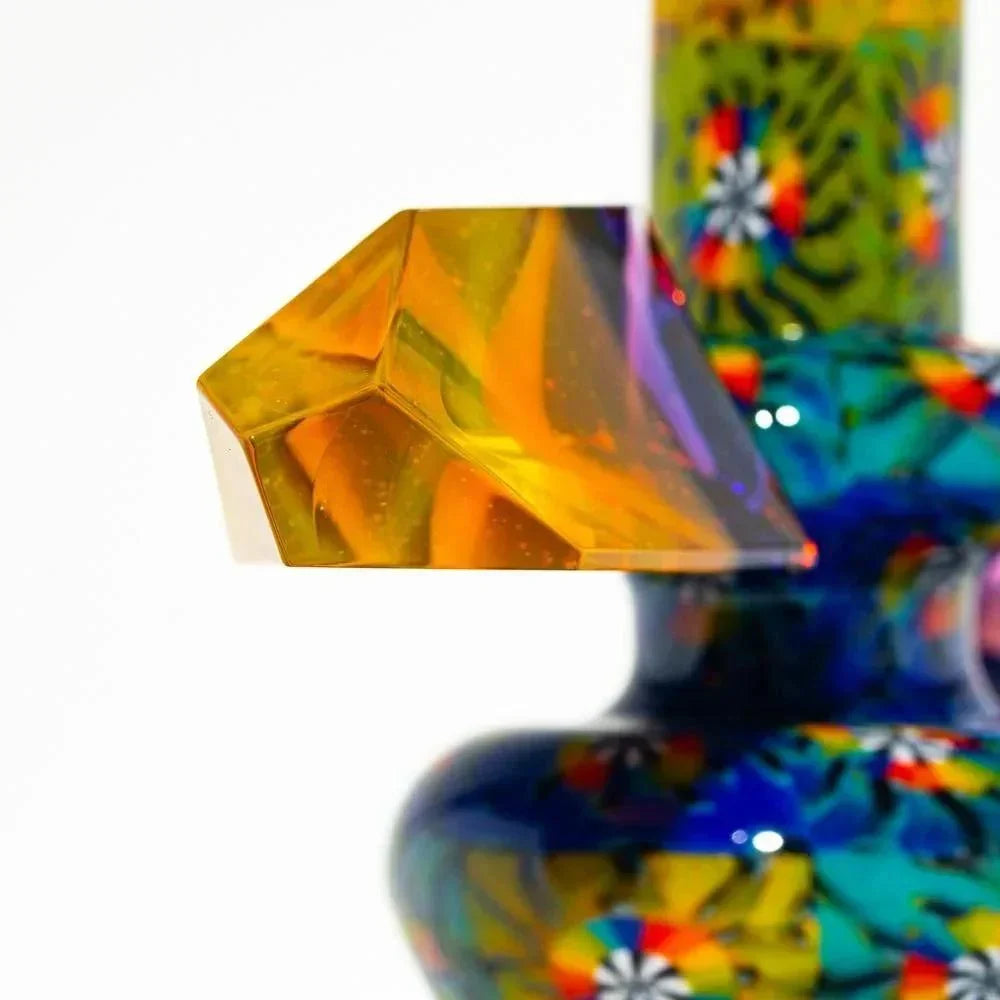 Colorful glass mini tube with intricate patterns and a yellow geometric handle