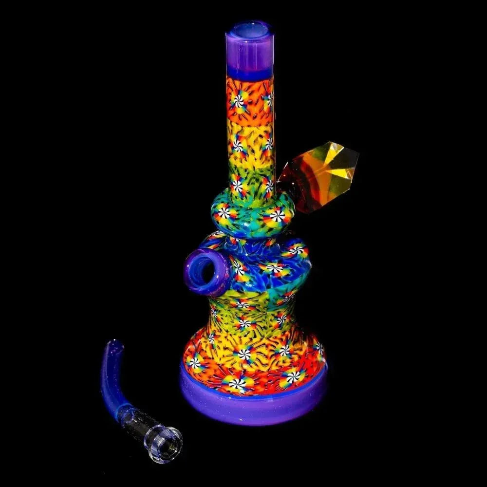 Colorful glass water pipe with psychedelic patterns and jewel accent, displayed on black background.