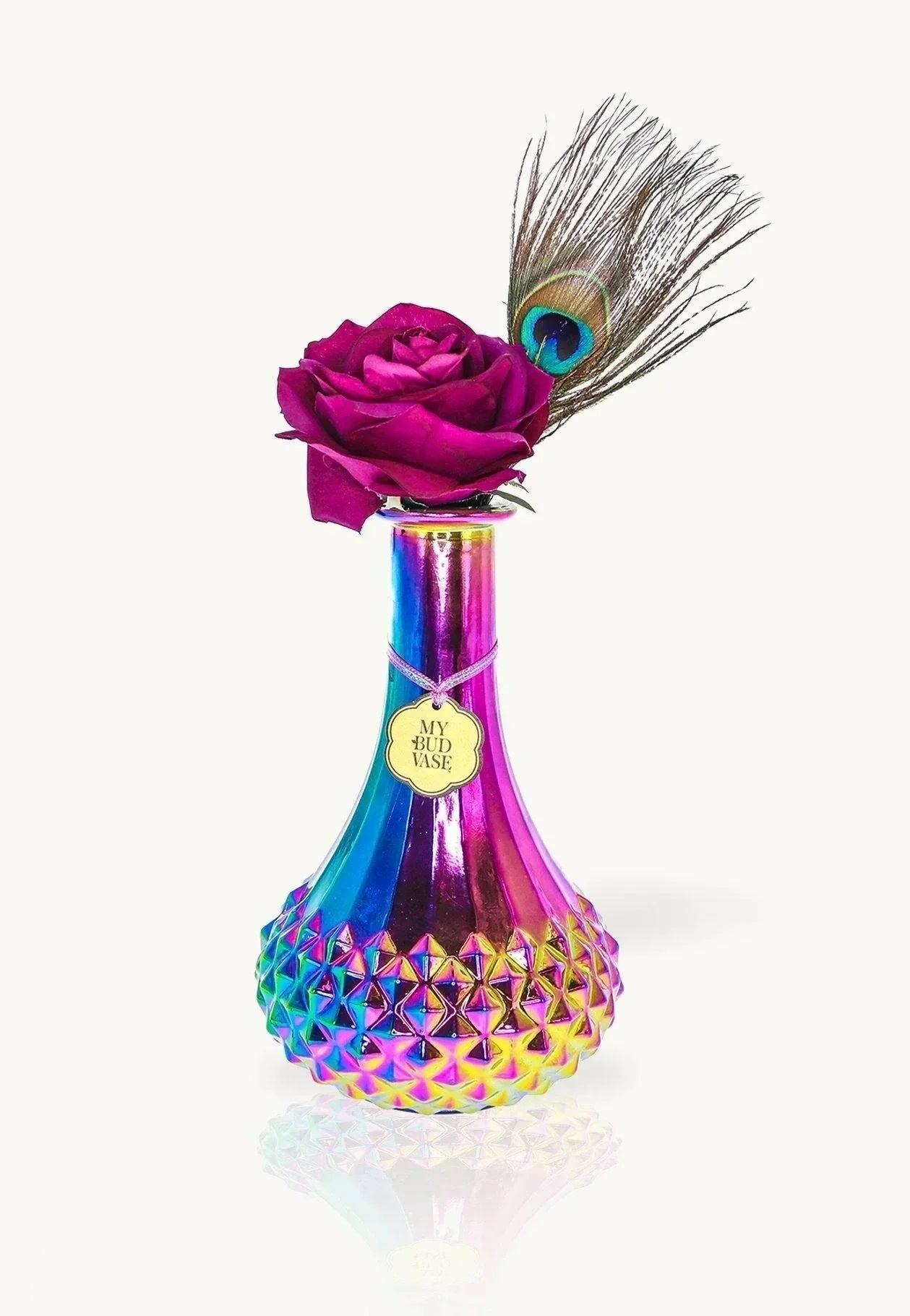 Iridescent glass vase with geometric texture, purple rose, and peacock feather accent