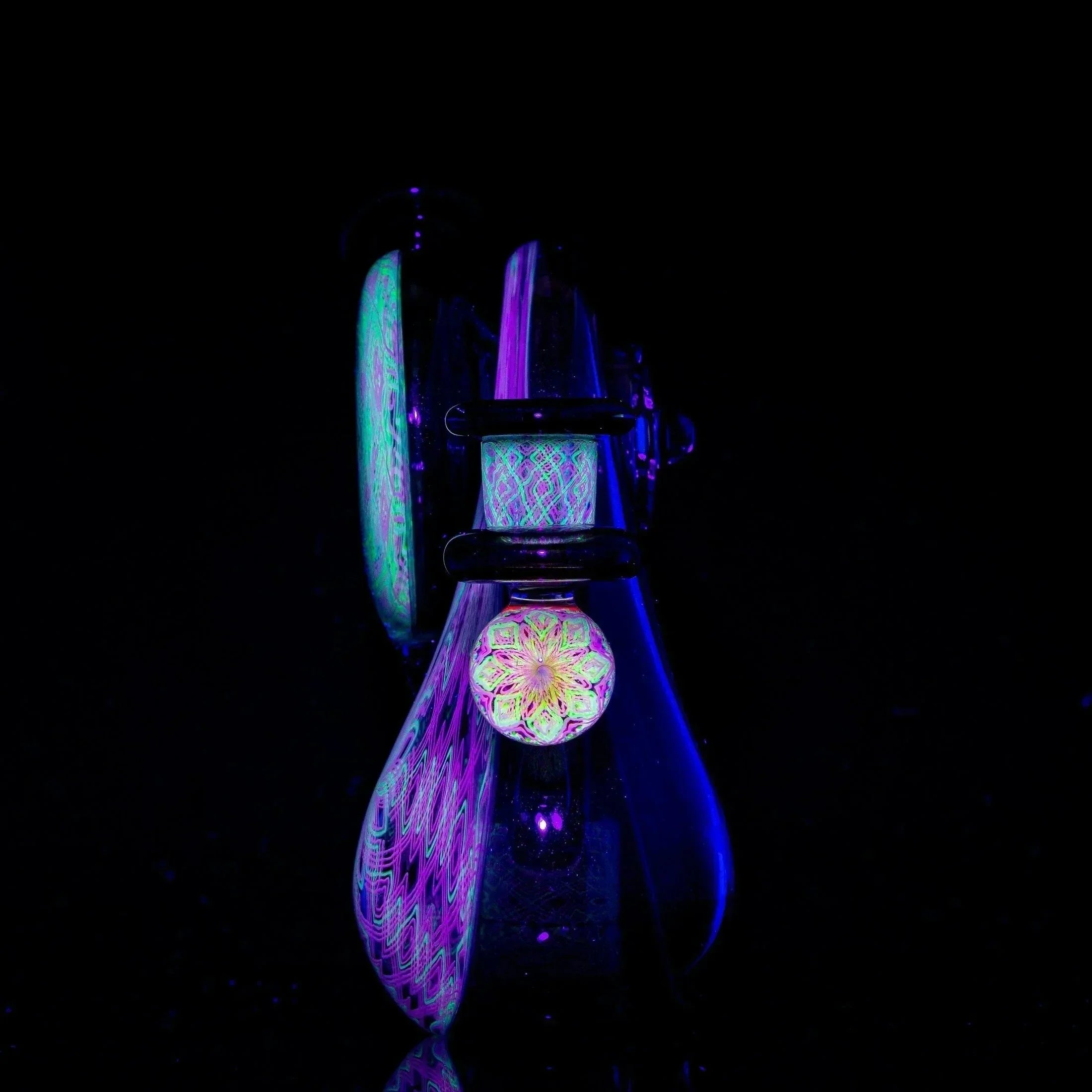 Colorful heady glass pipe with intricate patterns glowing under black light