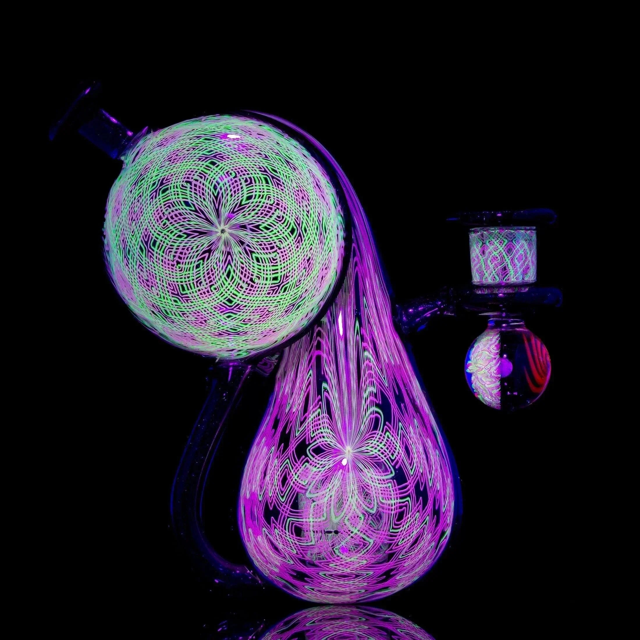 Heady glass water pipe with intricate UV-reactive patterns in purple, green, and pink
