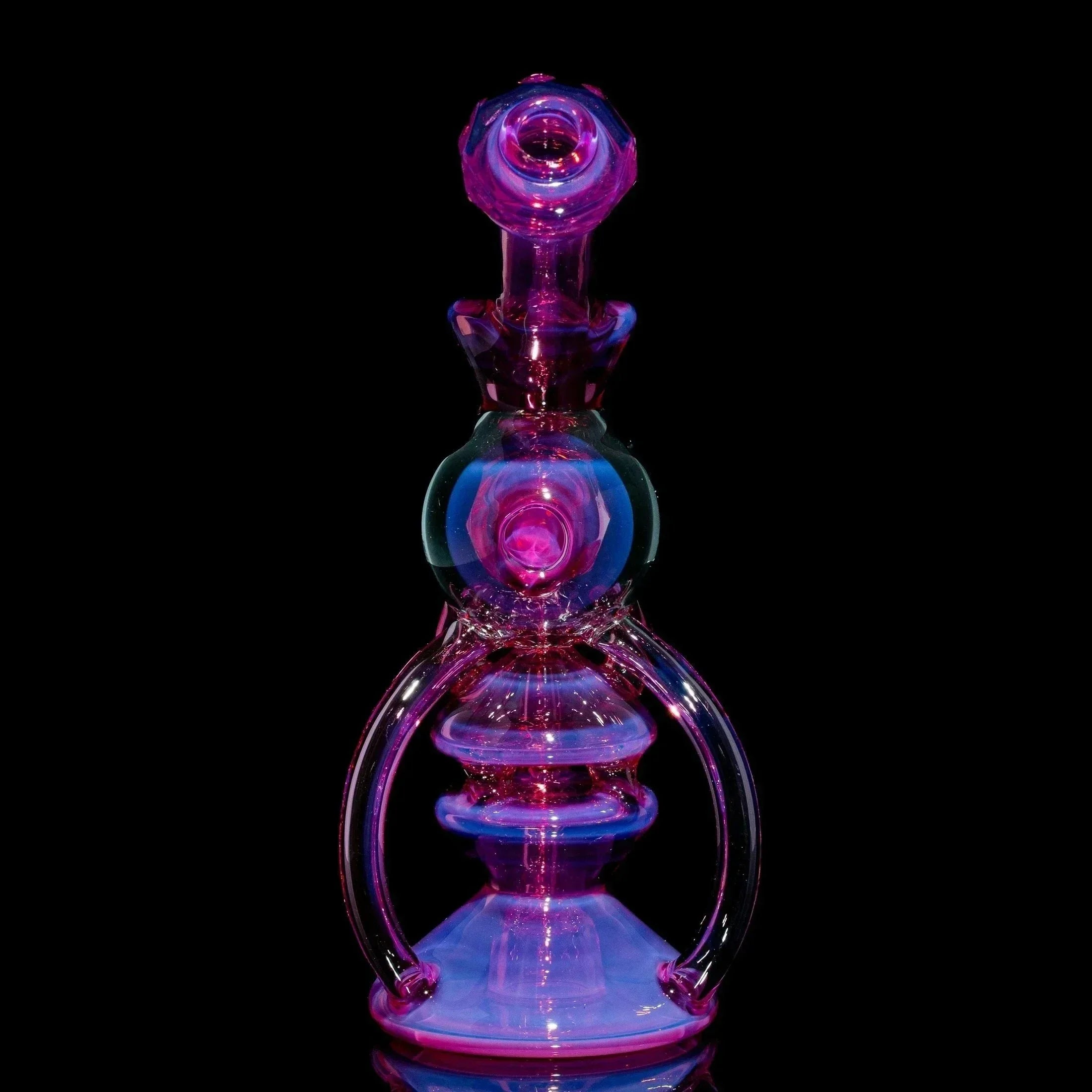 Telemagenta orb recycler glass water pipe with intricate shapes on black background