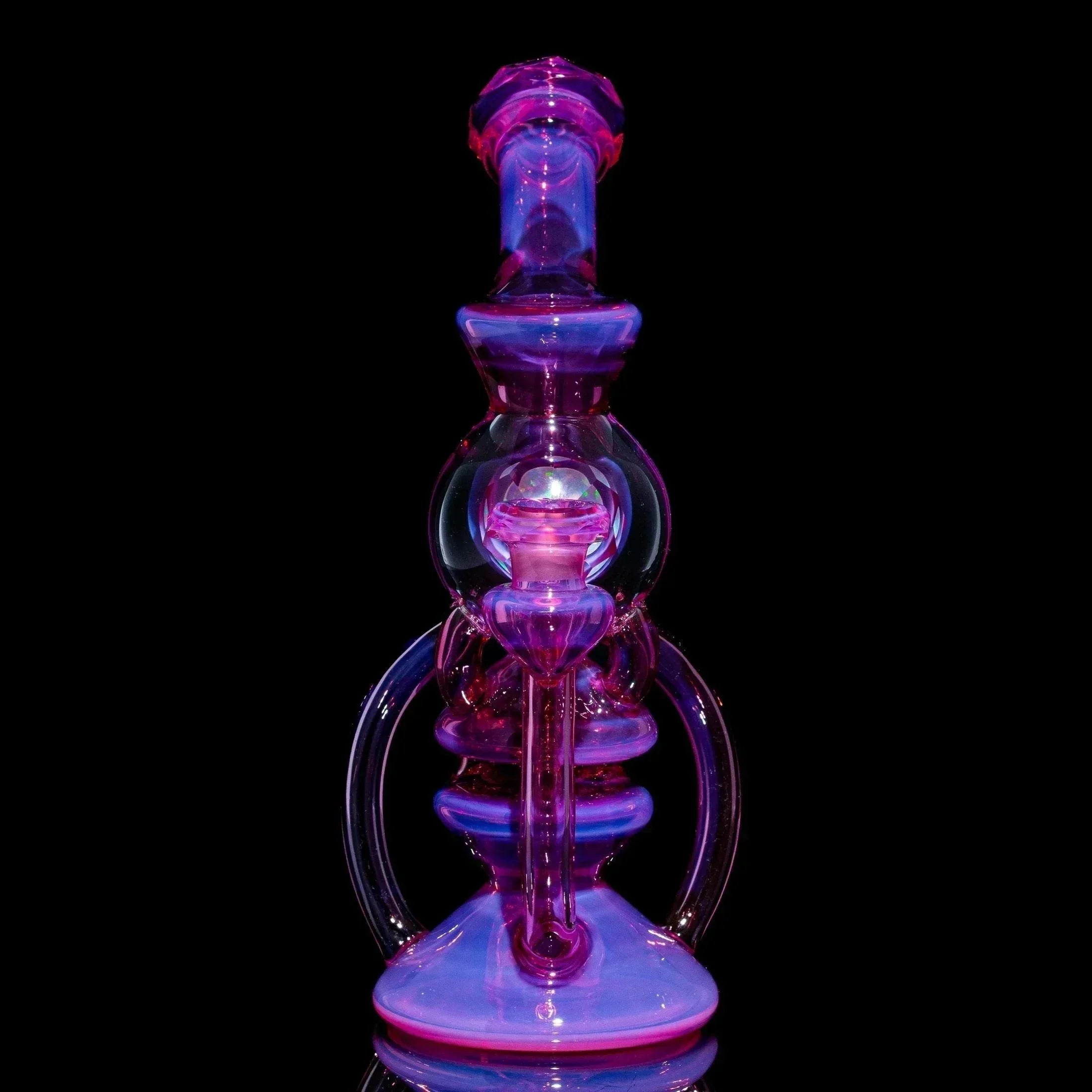Telemagenta orb recycler glass water pipe with intricate design on black background