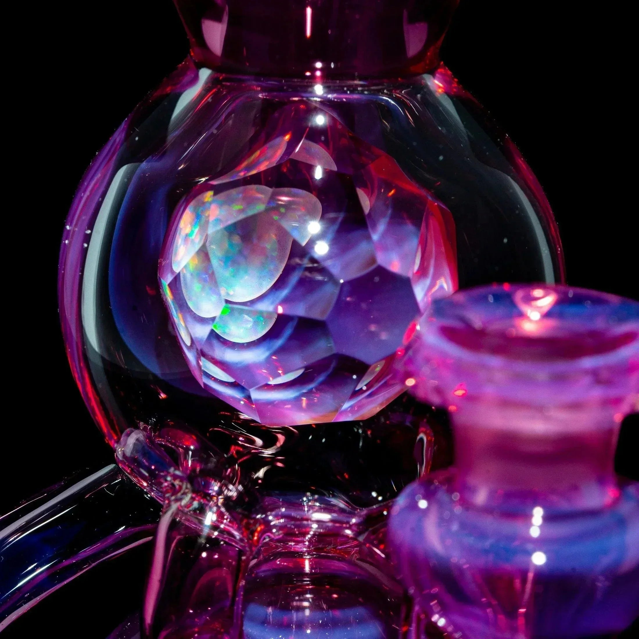 Close-up of a telemagenta glass orbcycler with iridescent opal accents and intricate details