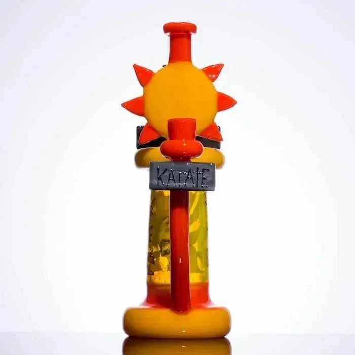 Colorful sun-themed glass pipe with 'KARATE' sign, vibrant orange and yellow design
