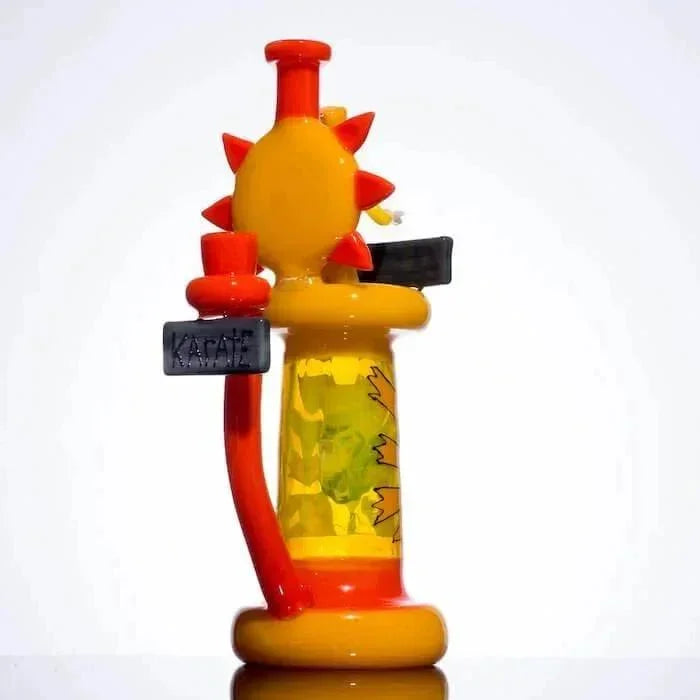 Colorful glass bong with sun design, orange accents, and 'KARATE' sign, ideal for heady glass collectors.