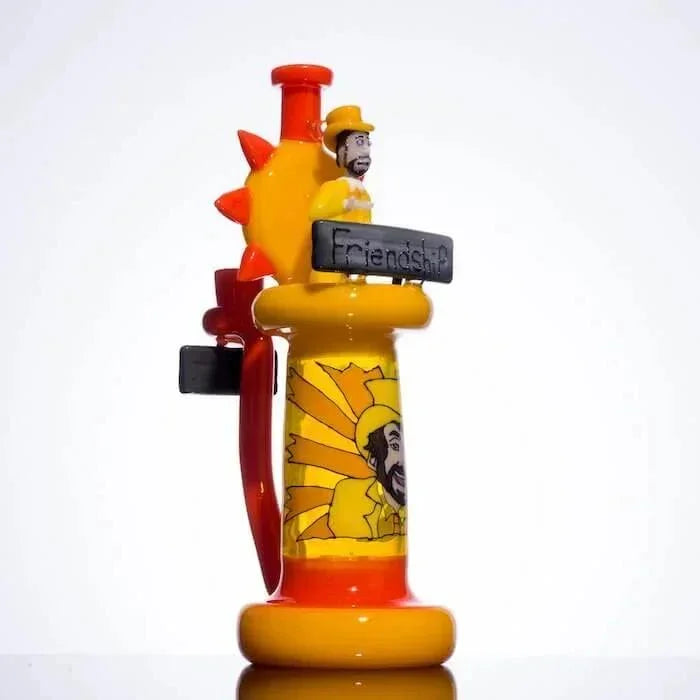 Colorful glass pipe with sun design, bearded figure, and 'Friendship' sign, heady glass art piece