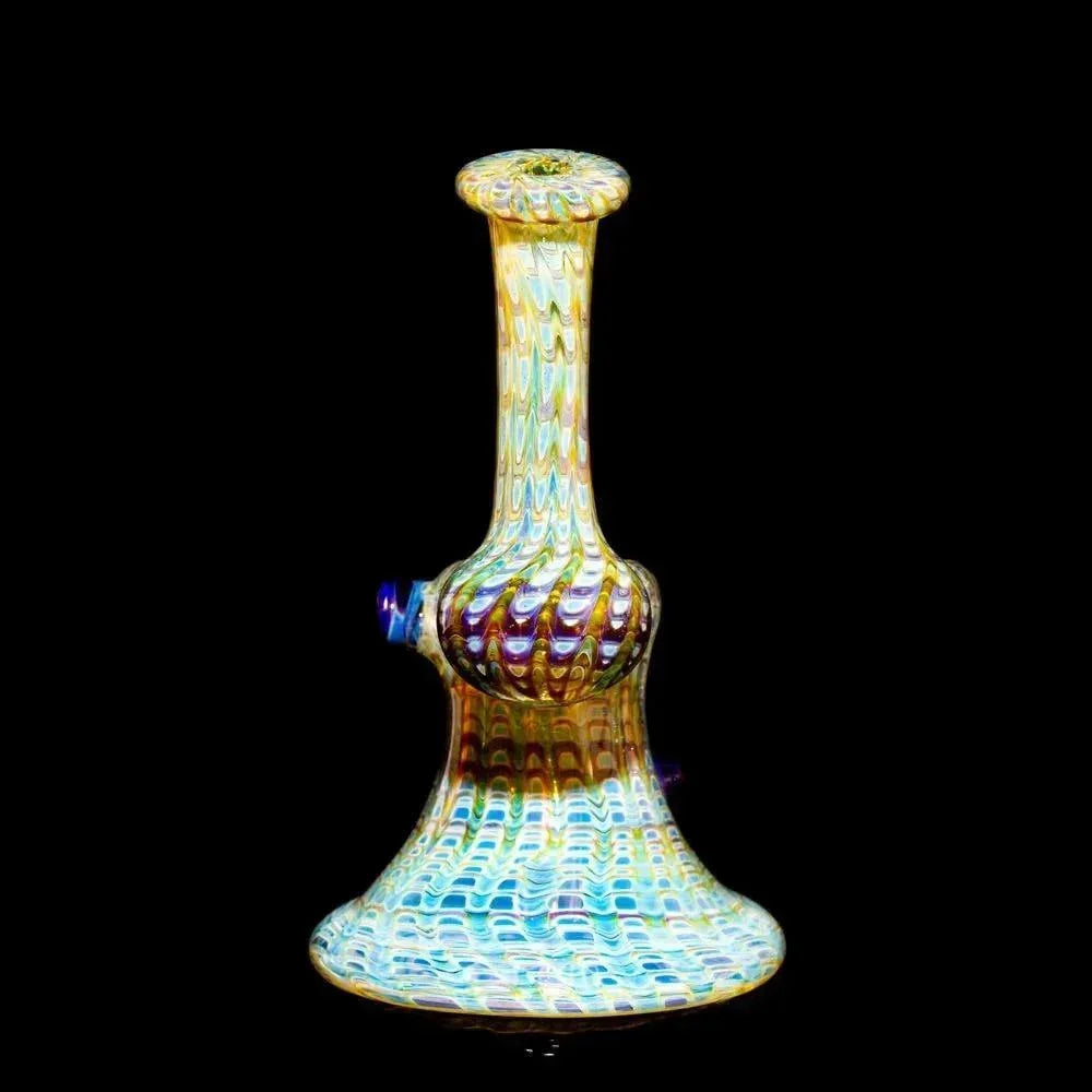 Hand-blown amber and blue glass bubbler pipe with intricate patterns on a black background