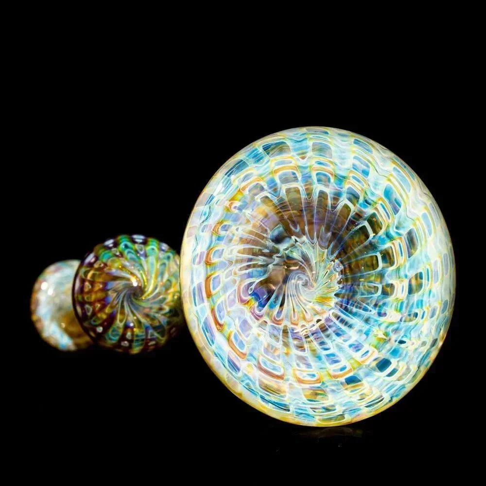 Colorful amber and blue glass bubbler with intricate swirl design on black background