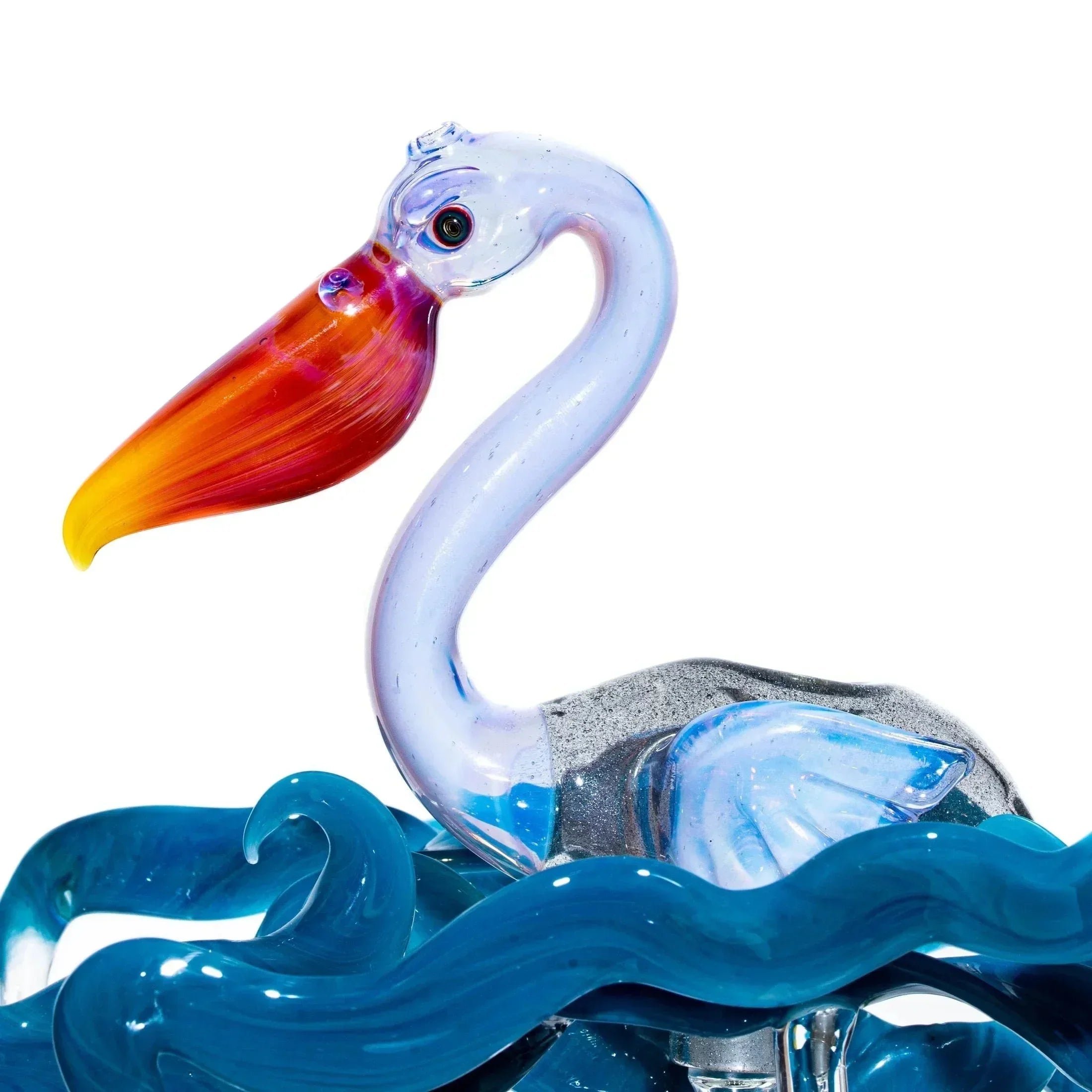 Hand-blown glass pelican sculpture with orange beak and blue wave base