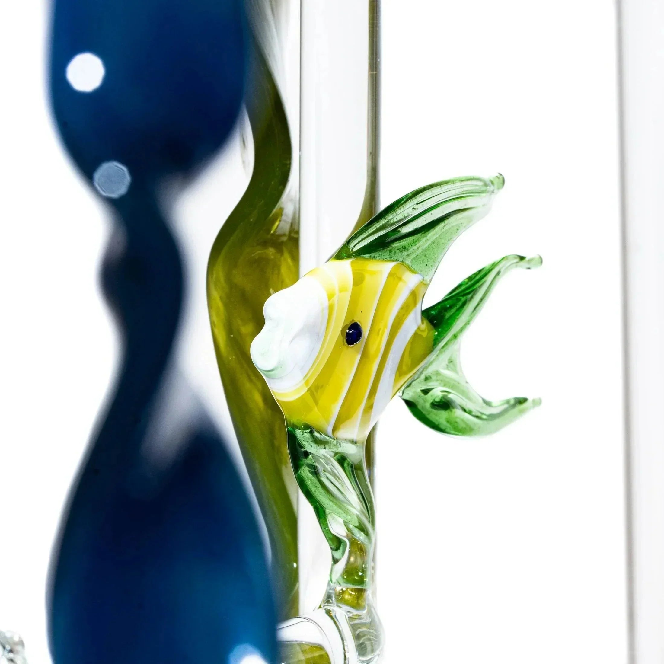Detailed glass art sculpture featuring a yellow and green fish accent on clear glass
