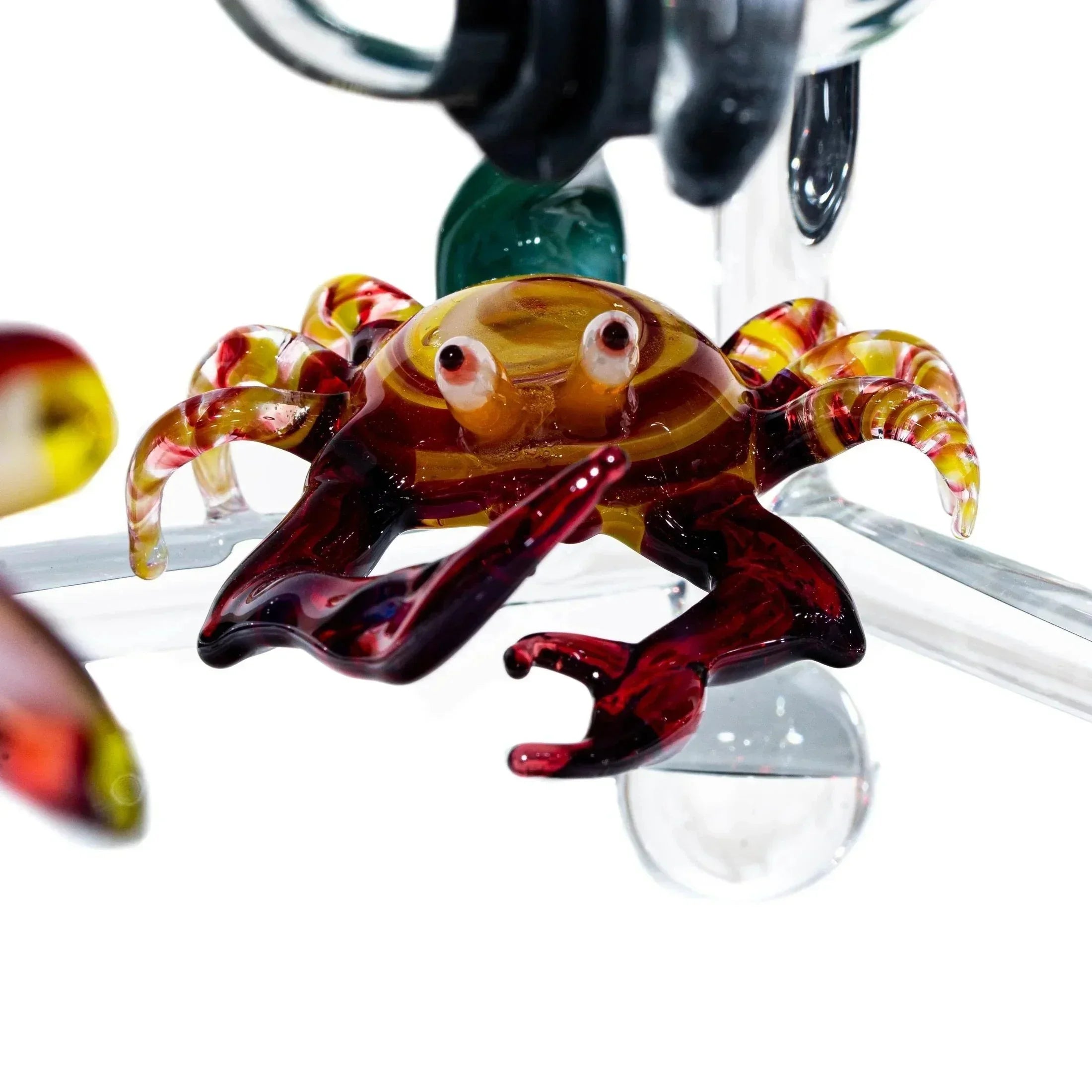 Colorful glass crab sculpture with detailed claws and legs on a clear glass structure