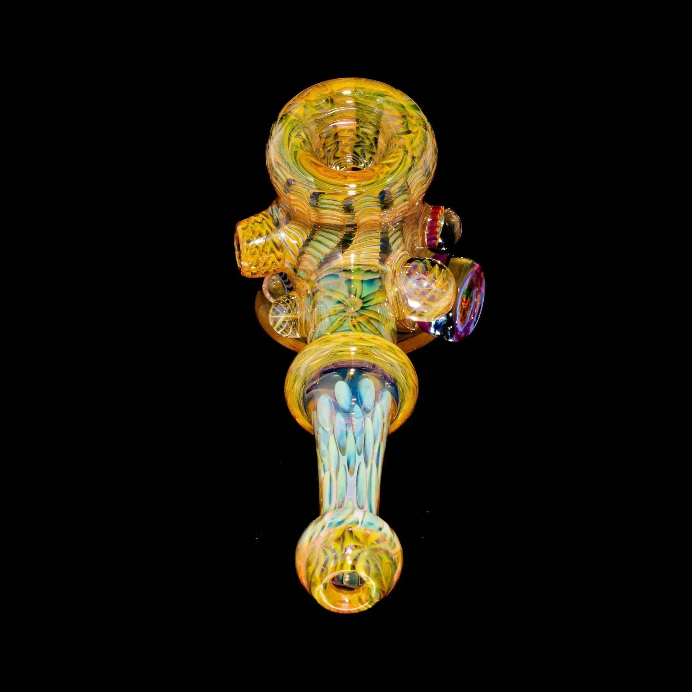 Intricate yellow and multicolor heady glass hand pipe with textured details on black background