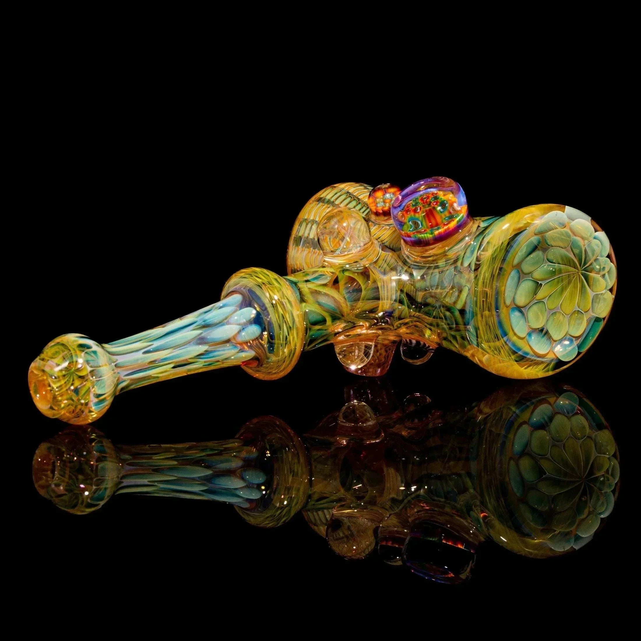 Heady glass hand pipe with intricate patterns and colorful accents on a black background