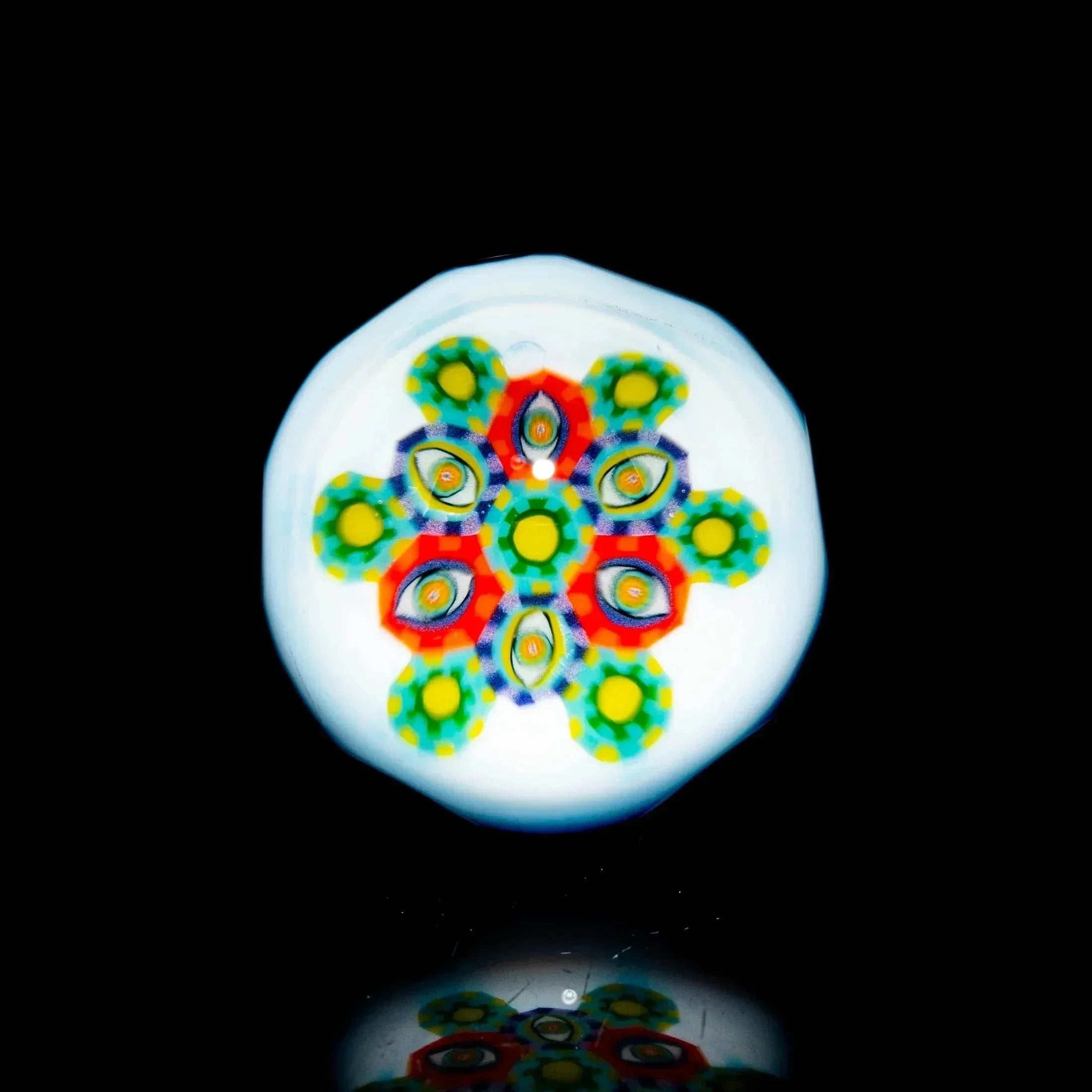 Intricate millefiori pattern on a round heady glass art piece with vibrant colors