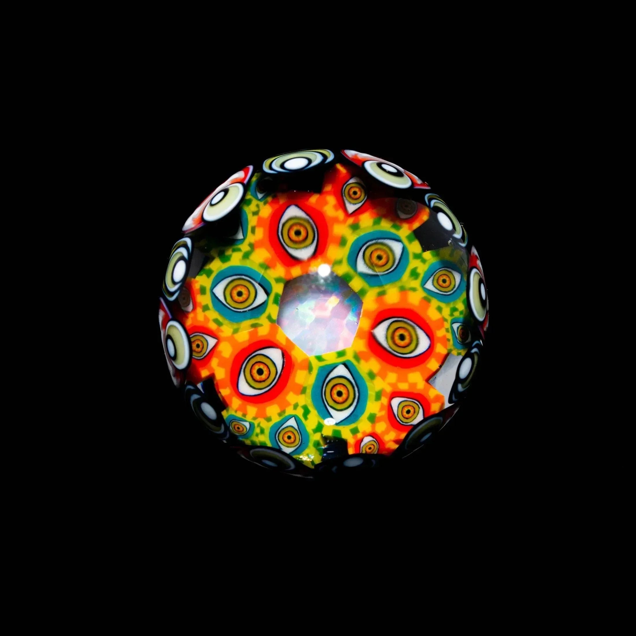 Colorful borosilicate glass marble with intricate psychedelic eye patterns on black background