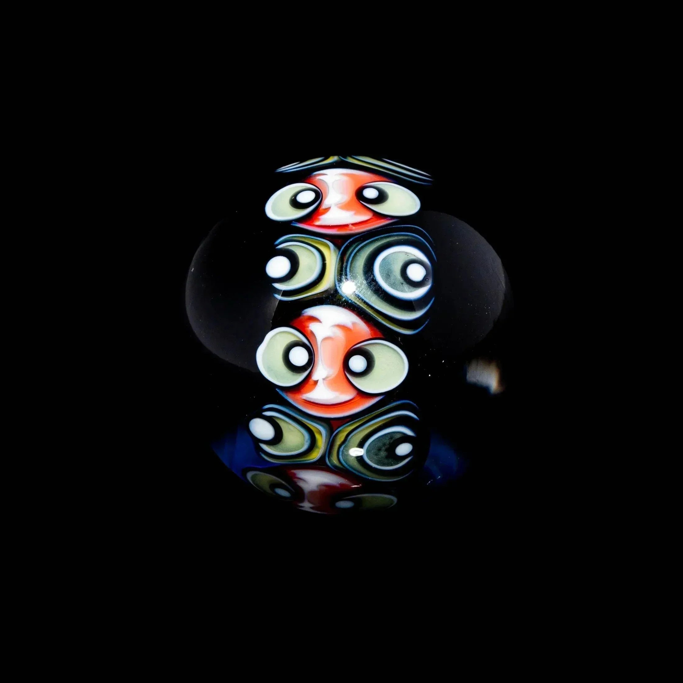 Heady glass marble with vibrant, detailed millefiori face patterns on a black background