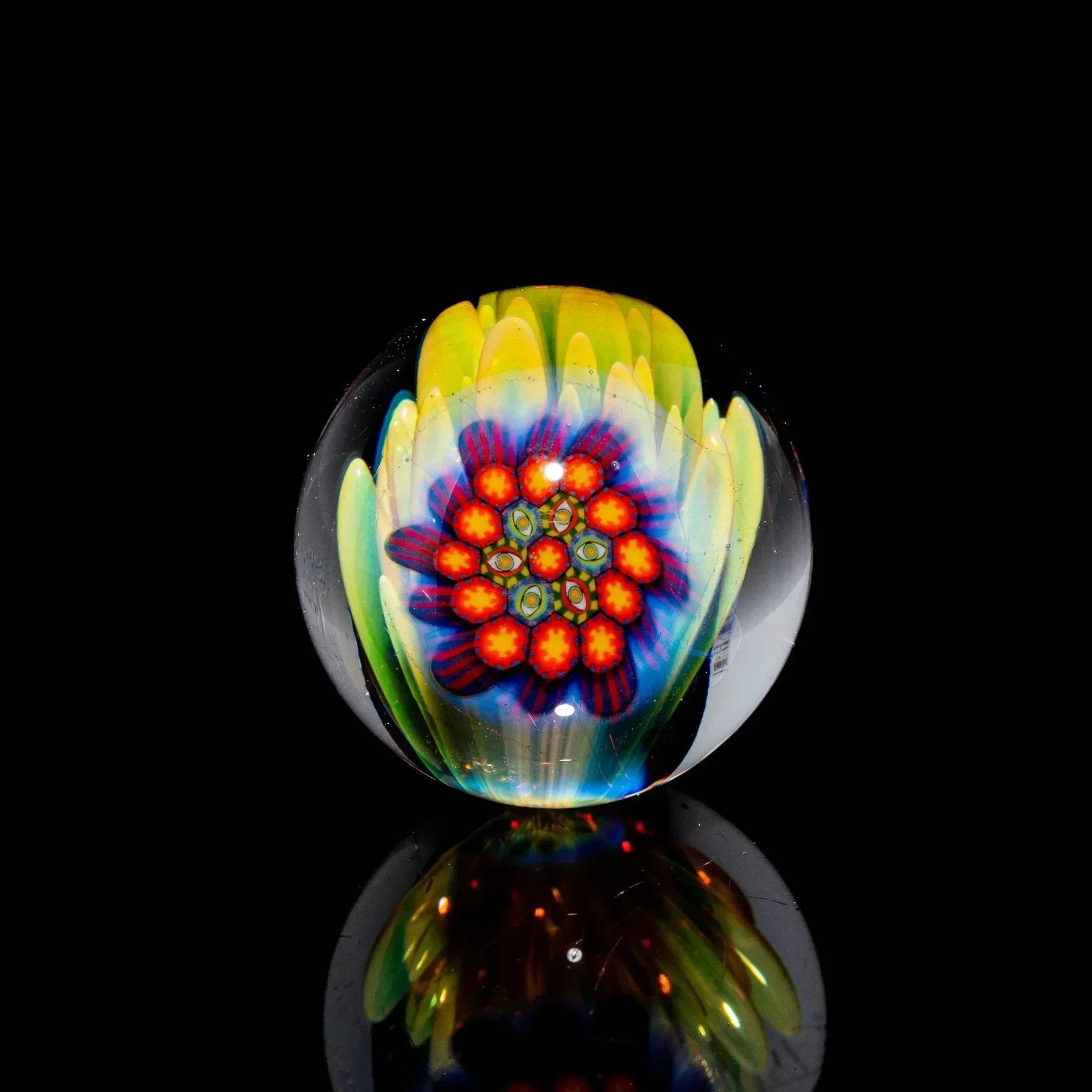 Heady glass marble with vibrant floral design, red petals, and yellow accents on black background