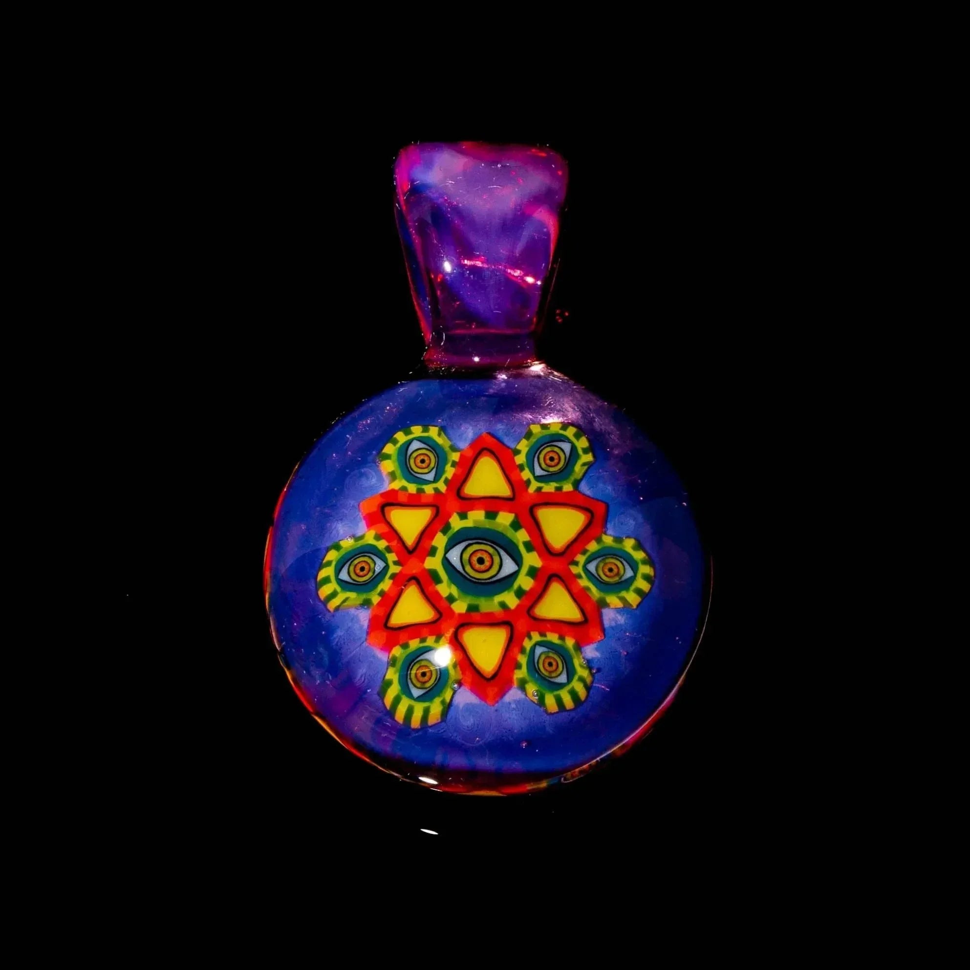 Colorful glass pendant with geometric eye design on blue background, photographed on black