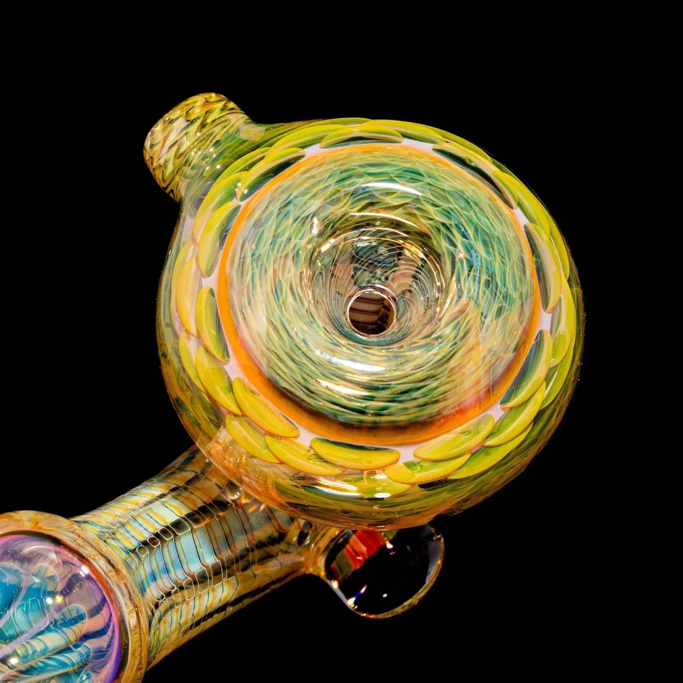 Colorful hand-blown glass pipe with intricate swirl and leaf patterns on black background