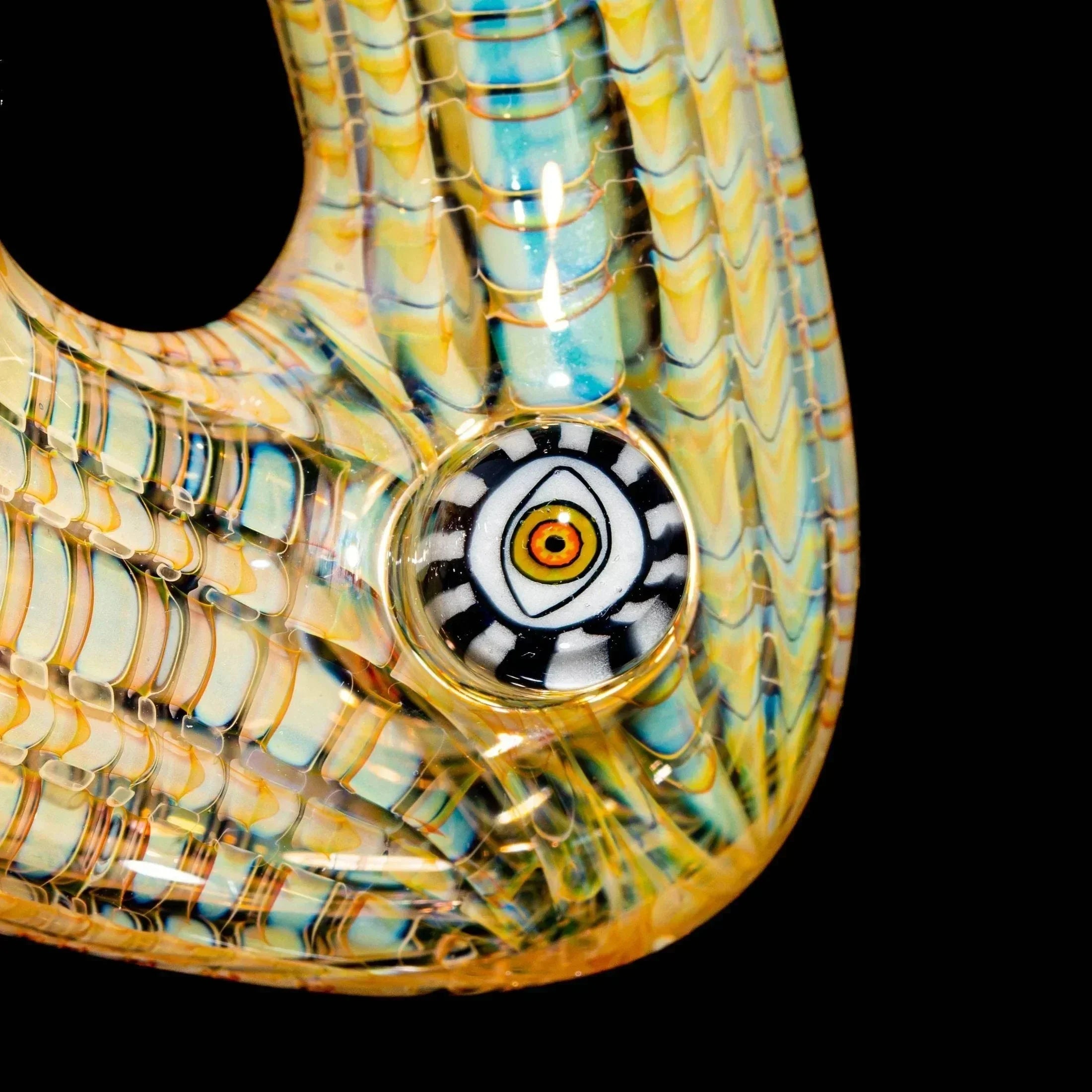 Close-up of intricate glass pipe with colorful fume patterns and detailed eye design