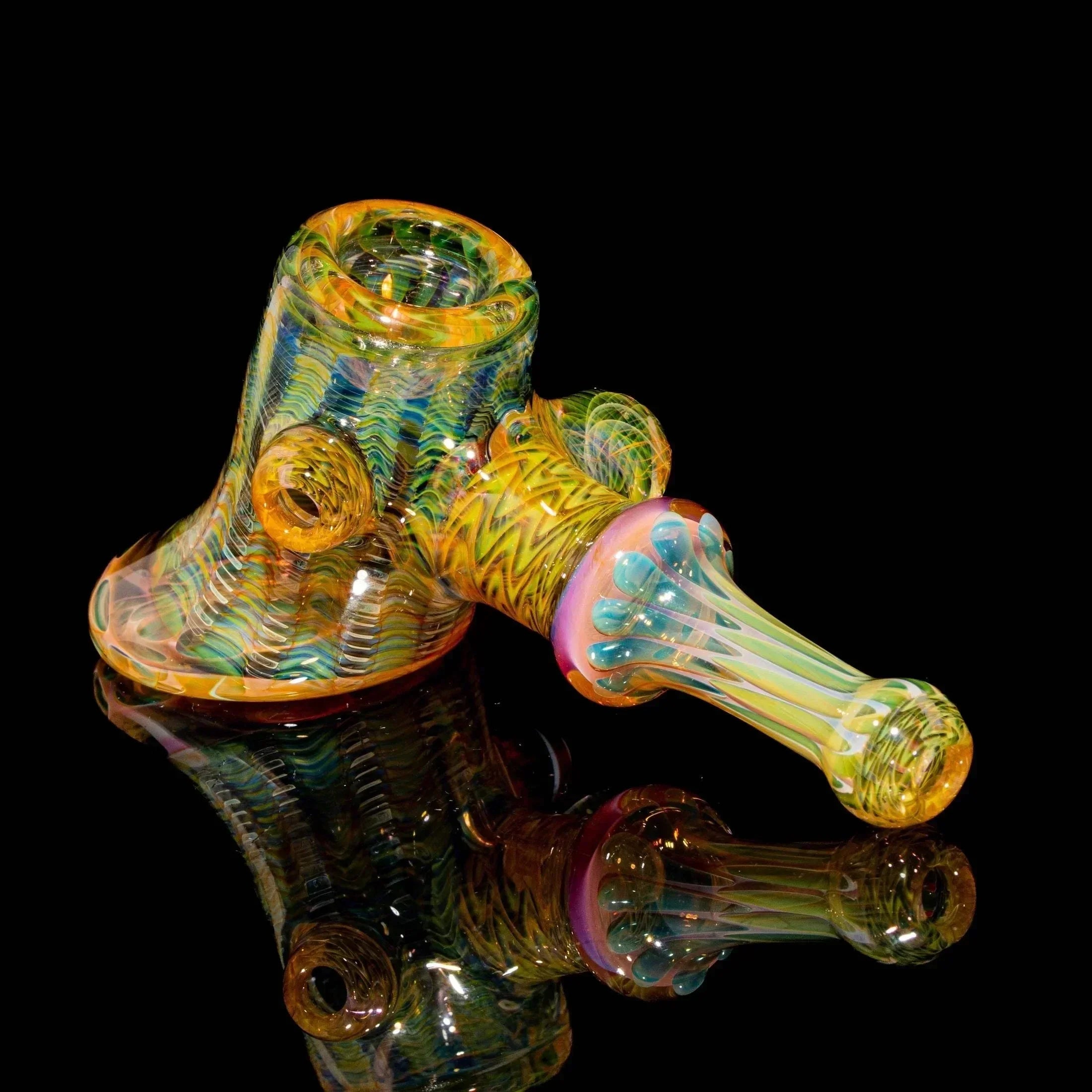 Heady glass hand pipe with colorful swirling patterns on a black background