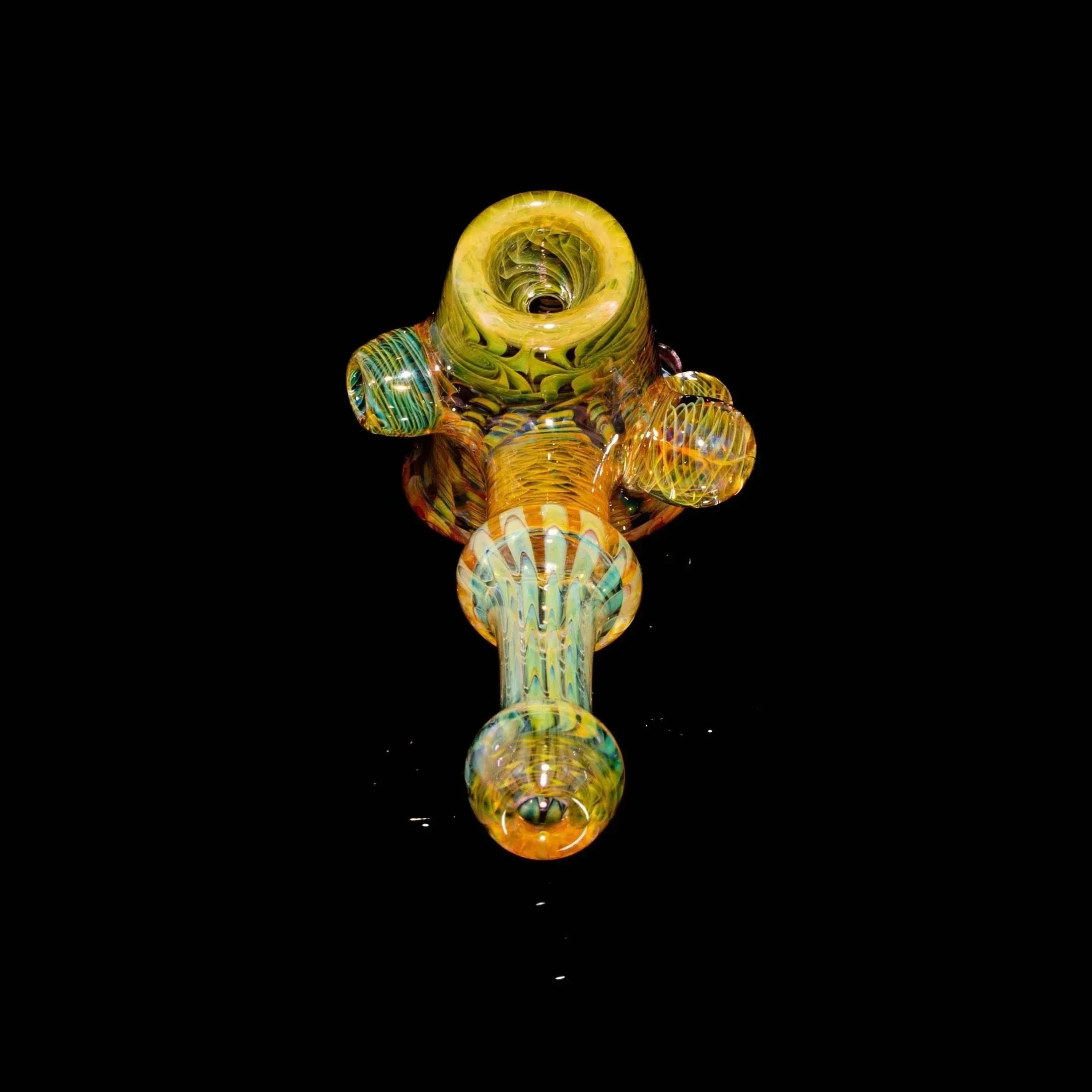 Hand-blown glass pipe with yellow, green, and blue accents on a black background