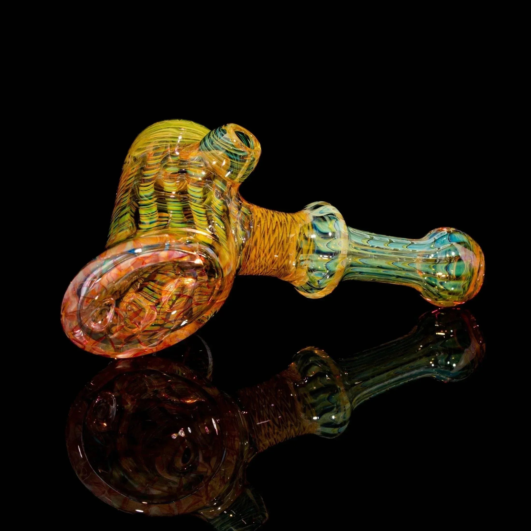 Heady glass hand pipe with vibrant colors and intricate patterns on black background