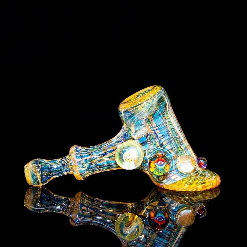 Hand-blown glass hammer pipe with intricate colorful patterns on a black background
